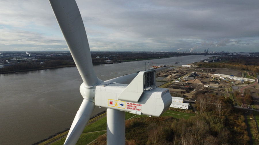 Foto van de kop van een windturbine met de rivier op de achtergrond